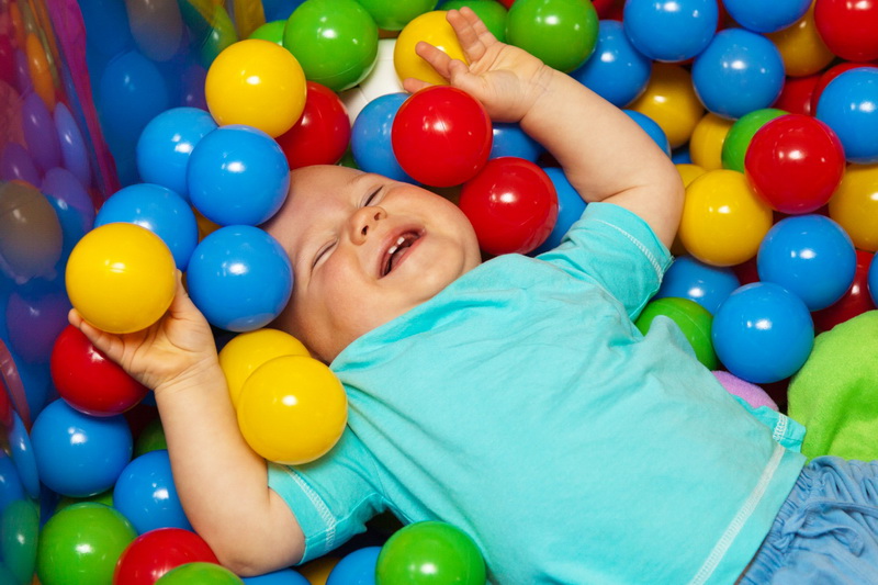 lachendes Baby in bunten Spielbällen